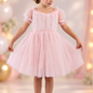 Girls birthday dress in light pink Swiss dot tulle with sheer puff sleeves, sweetheart neckline and knee-length skirt.